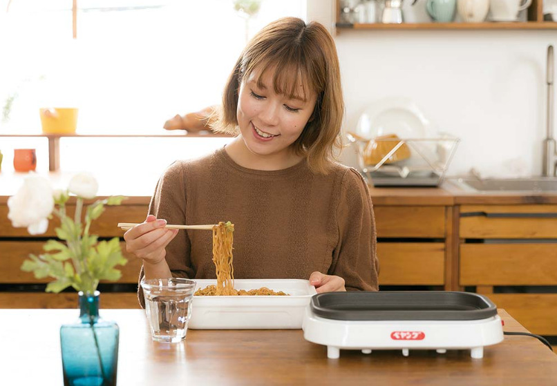 焼きペヤングメーカーでつくったペヤング焼きそばを食べる女性