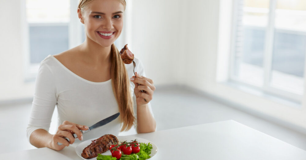 ステーキをおいしそうに食べる女性